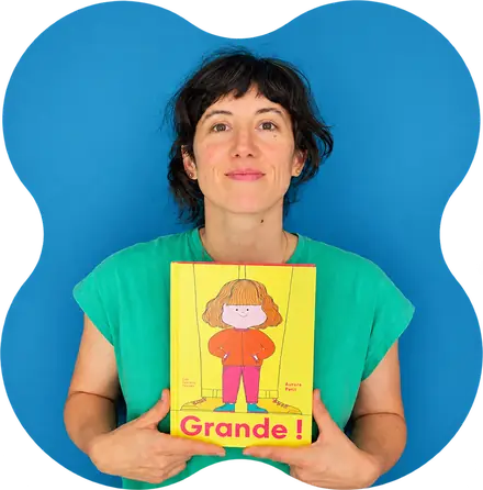 Aurore Petit, souriante, tient son album « Grande ! » (Les Fourmis rouges)